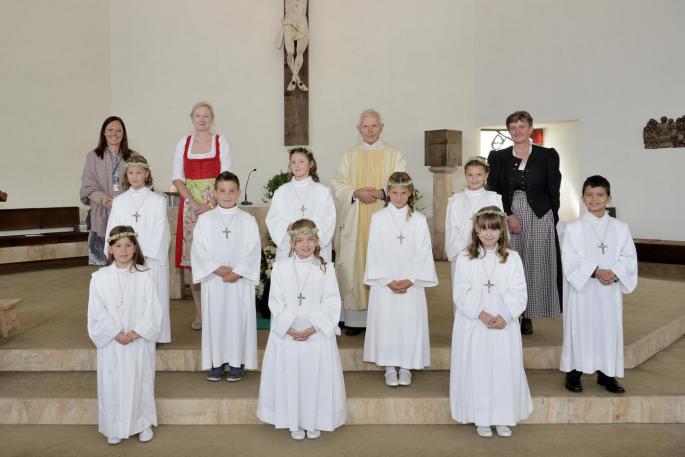 Erstkommunionskinder stehen vor dem Altar