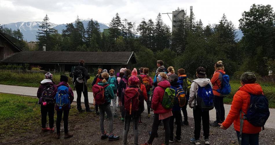 Schulklasse steht im Freien und hört zu