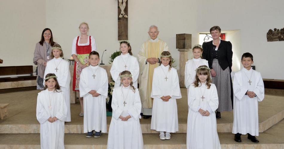 Erstkommunionskinder stehen vor dem Altar